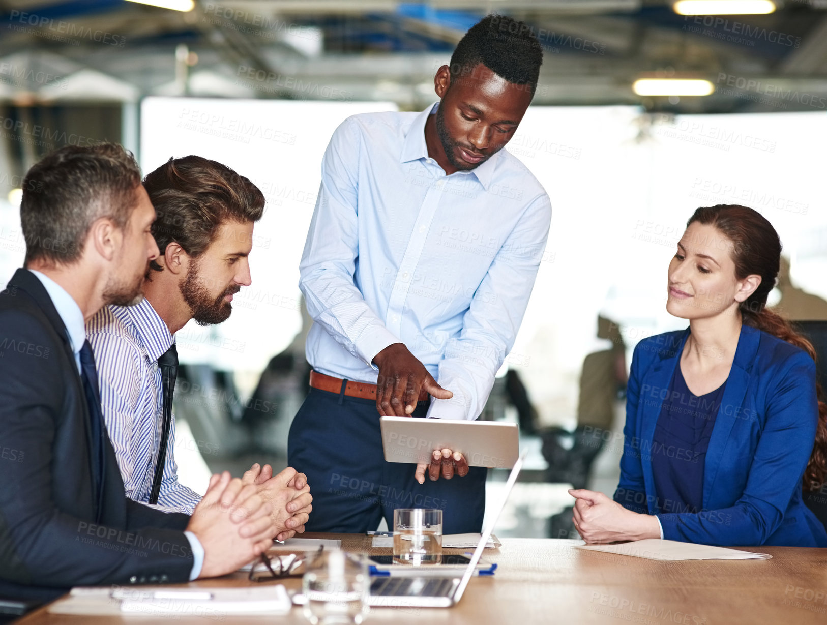 Buy stock photo Shot of a group of businesspeople discussing something on a digital tablet