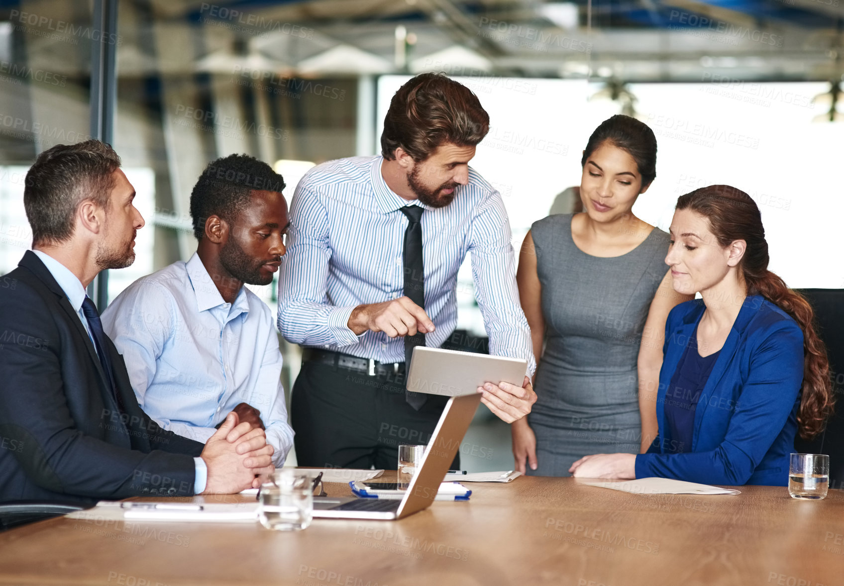 Buy stock photo Shot of a group of businesspeople discussing something on a digital tablet