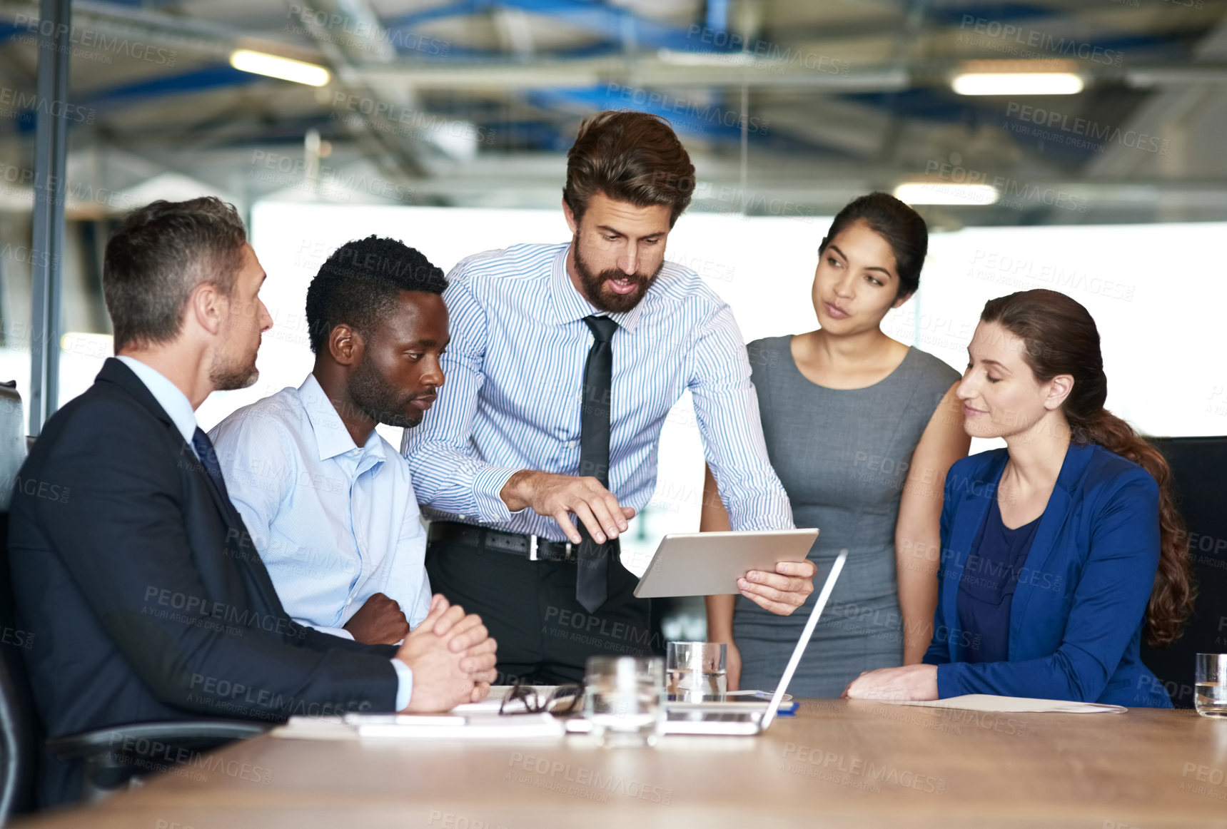 Buy stock photo Shot of a group of businesspeople discussing something on a digital tablet