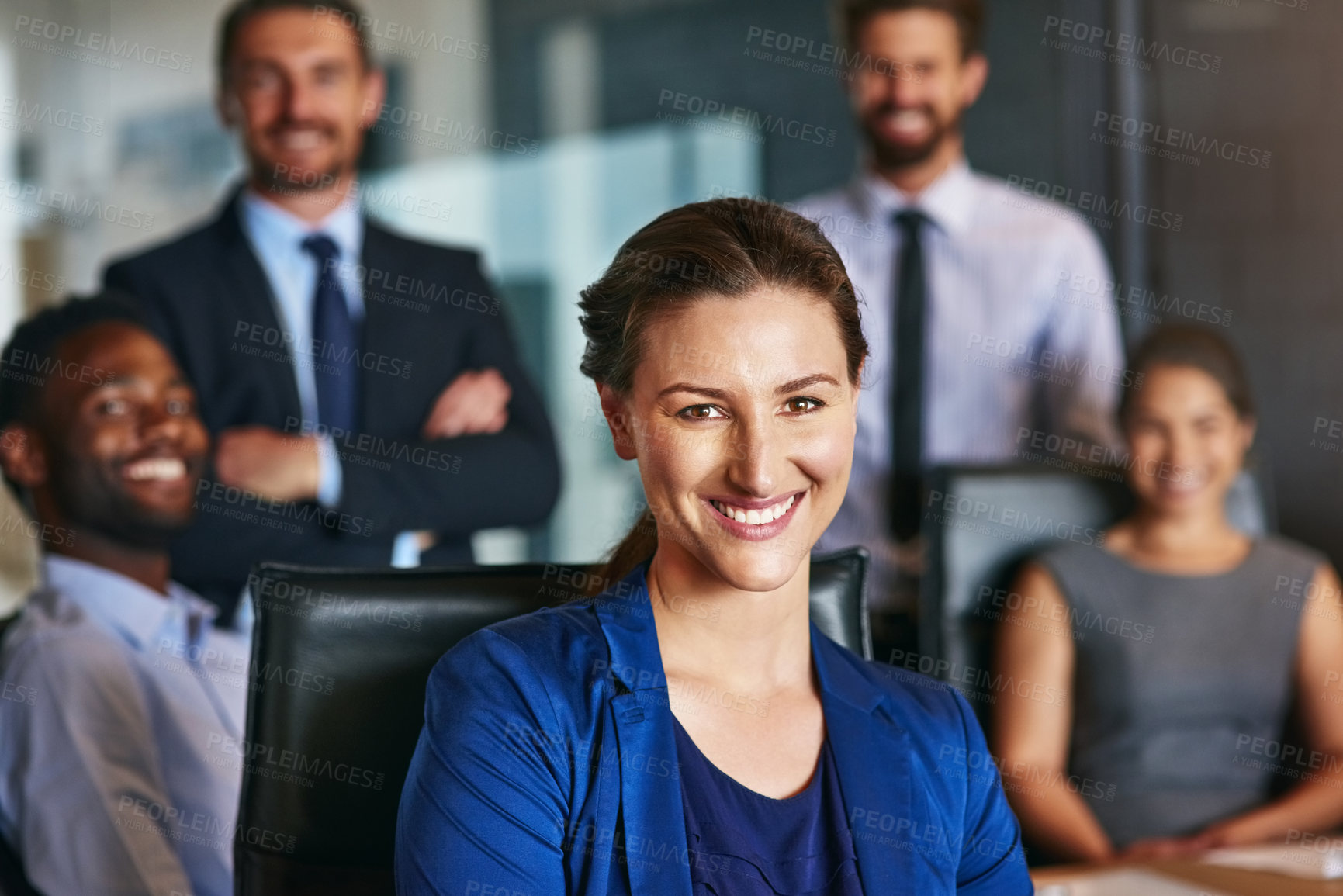 Buy stock photo Portrait of a smiling businesswoman sitting in an office with colleagues in the background