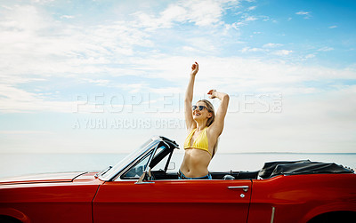 Buy stock photo Shot of a happy young woman enjoying a summer’s road trip