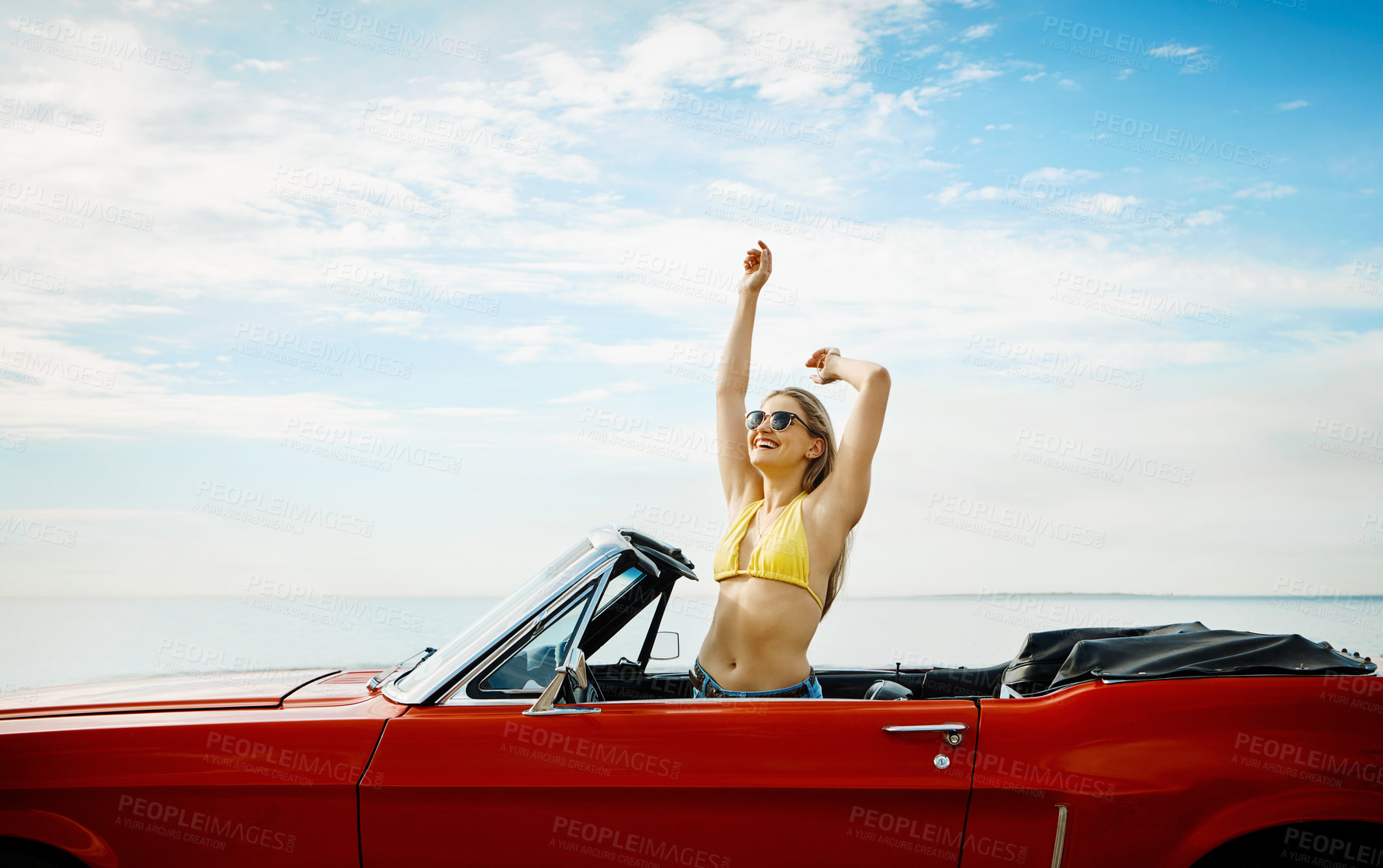 Buy stock photo Shot of a happy young woman enjoying a summer’s road trip