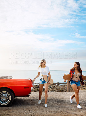 Buy stock photo Shot of two friends going skateboarding while on a road trip
