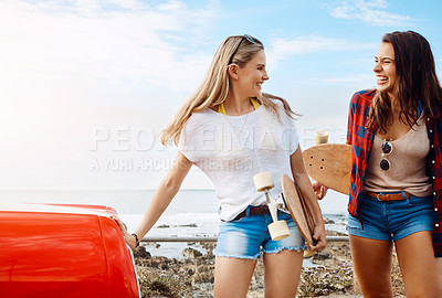 Buy stock photo Shot of two friends going skateboarding while on a road trip