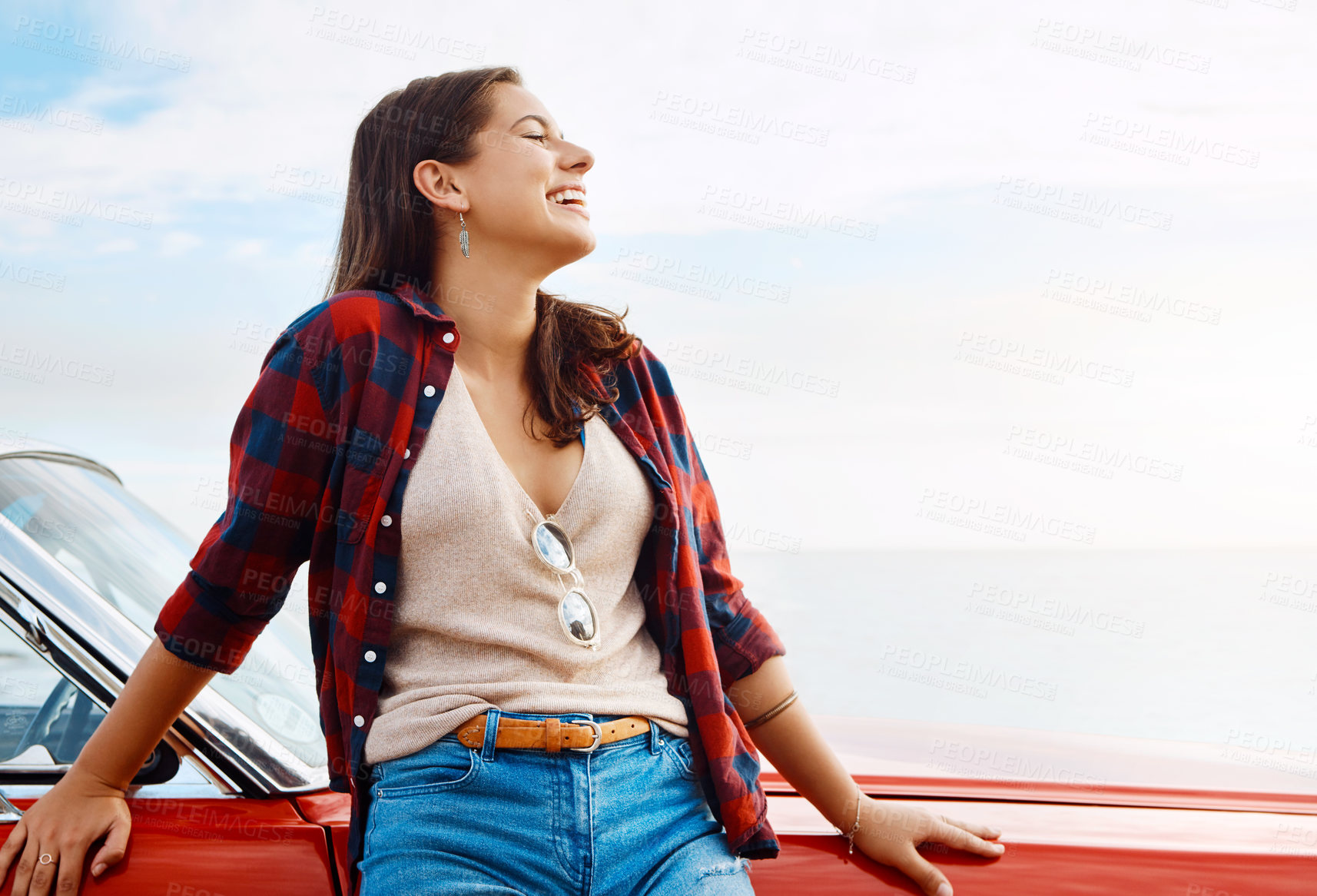 Buy stock photo Shot of a happy young woman enjoying a summer’s road trip