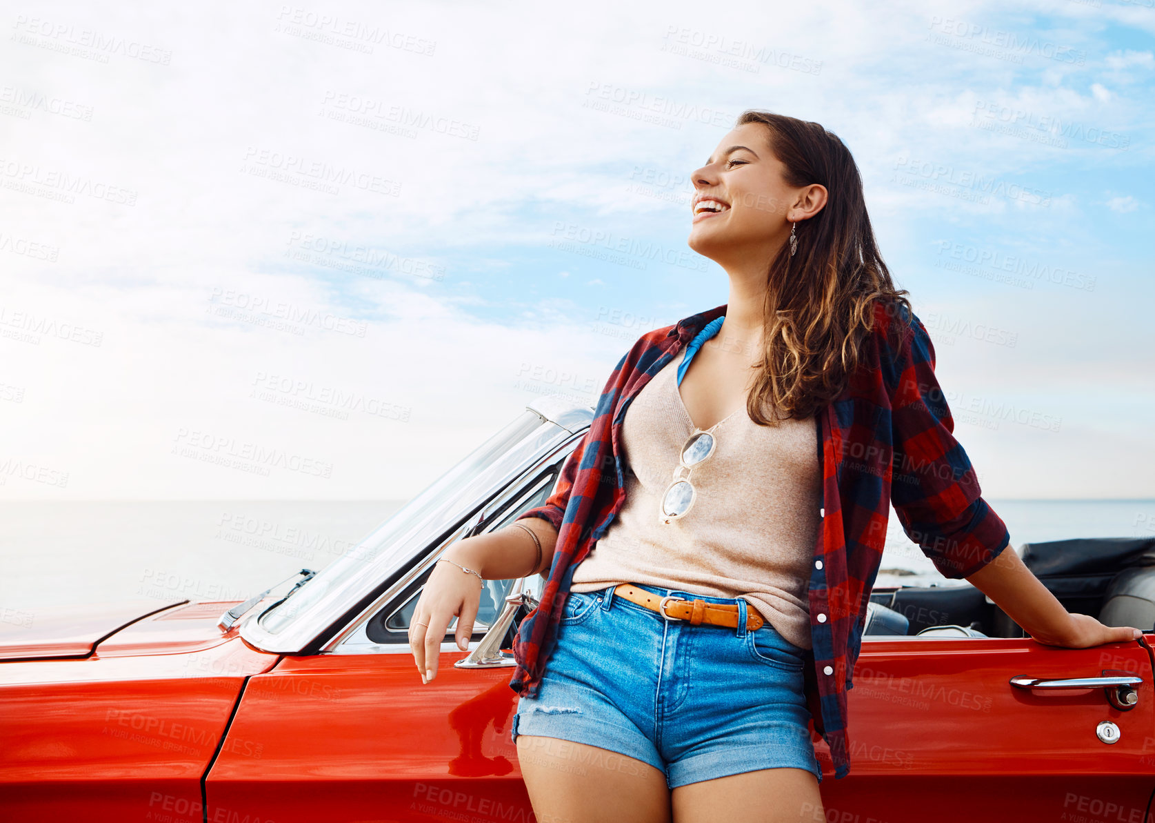 Buy stock photo Shot of a happy young woman enjoying a summer’s road trip