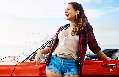 Buy stock photo Shot of a happy young woman enjoying a summer’s road trip