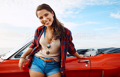 Buy stock photo Shot of a happy young woman enjoying a summer’s road trip