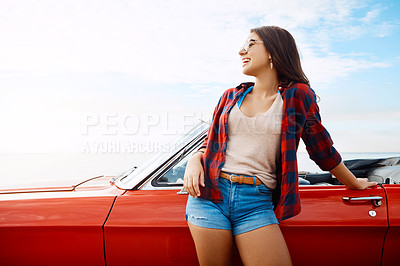 Buy stock photo Shot of a happy young woman enjoying a summer’s road trip