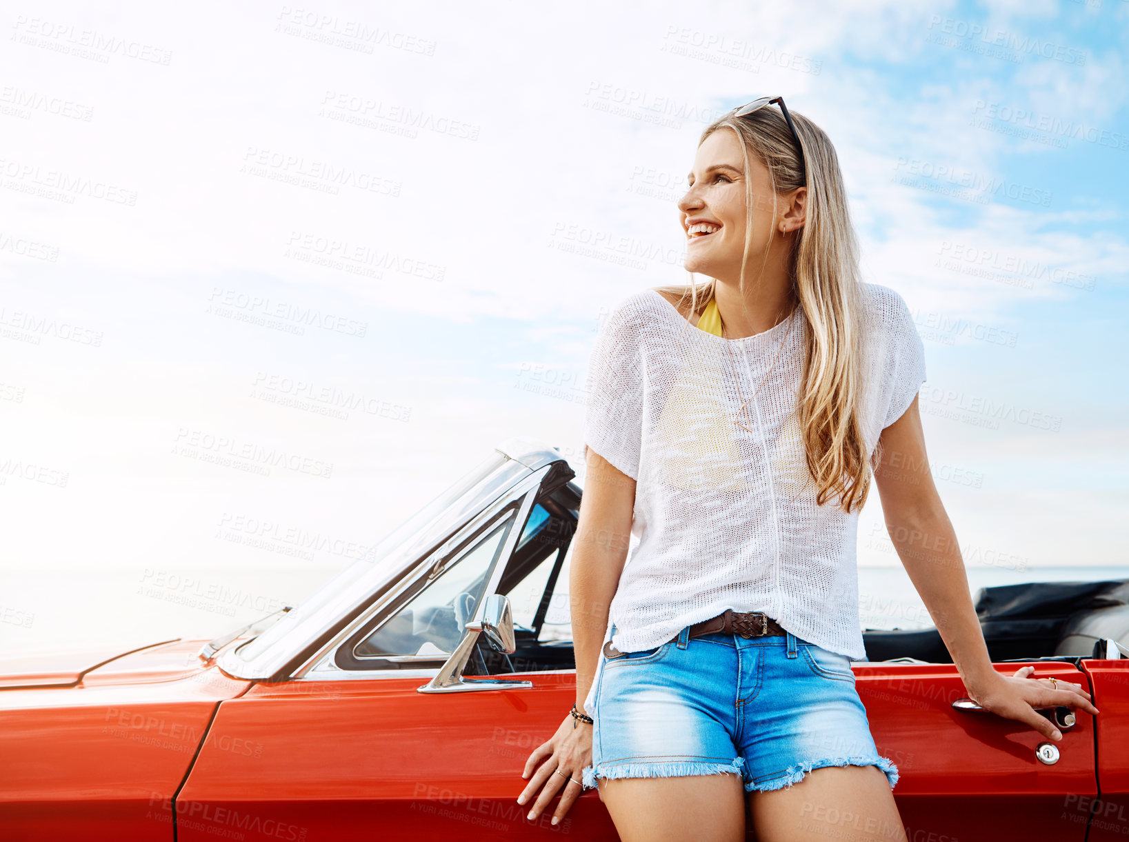 Buy stock photo Shot of a happy young woman enjoying a summer’s road trip