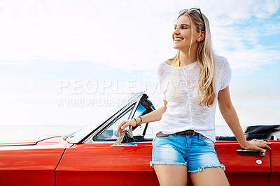 Buy stock photo Shot of a happy young woman enjoying a summer’s road trip