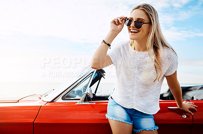 Buy stock photo Shot of a happy young woman enjoying a summer’s road trip