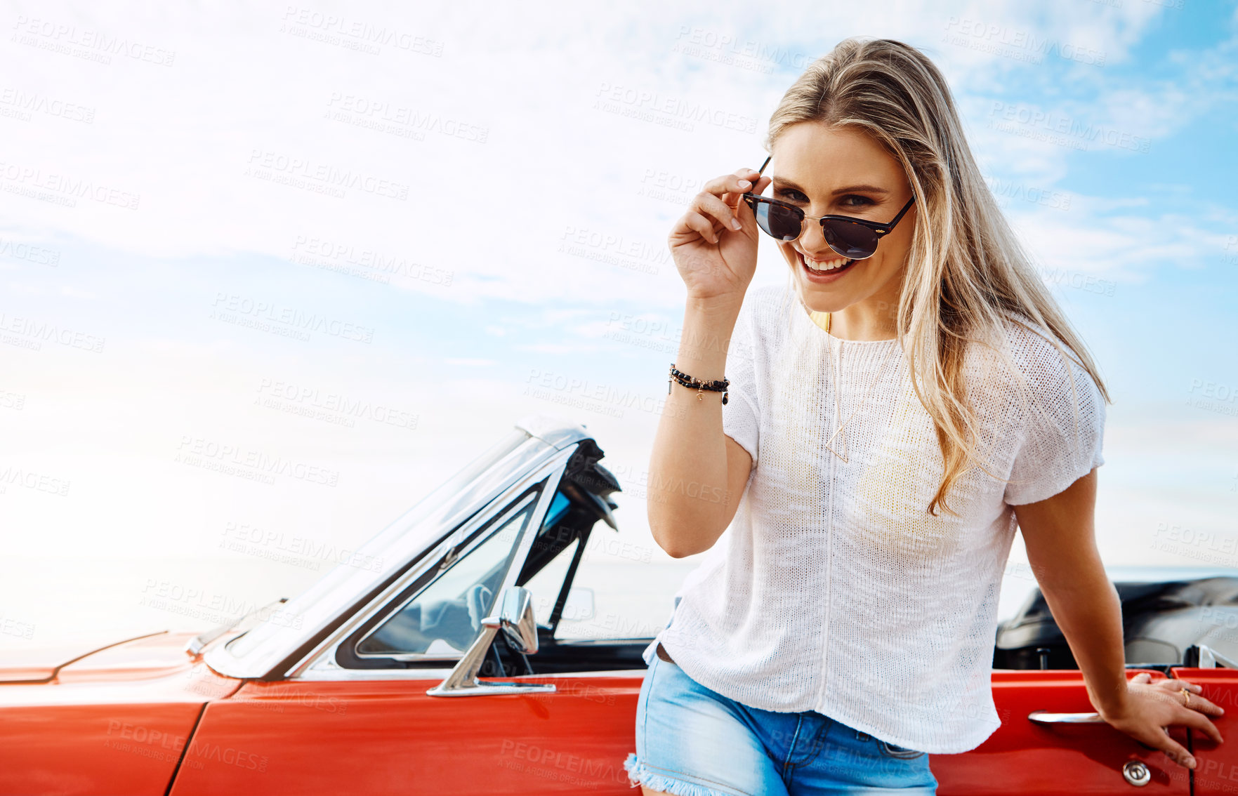 Buy stock photo Shot of a happy young woman enjoying a summer’s road trip