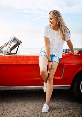 Buy stock photo Shot of a happy young woman enjoying a summer’s road trip