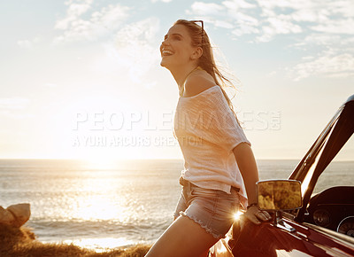 Buy stock photo Shot of a happy young woman enjoying a summer’s road trip