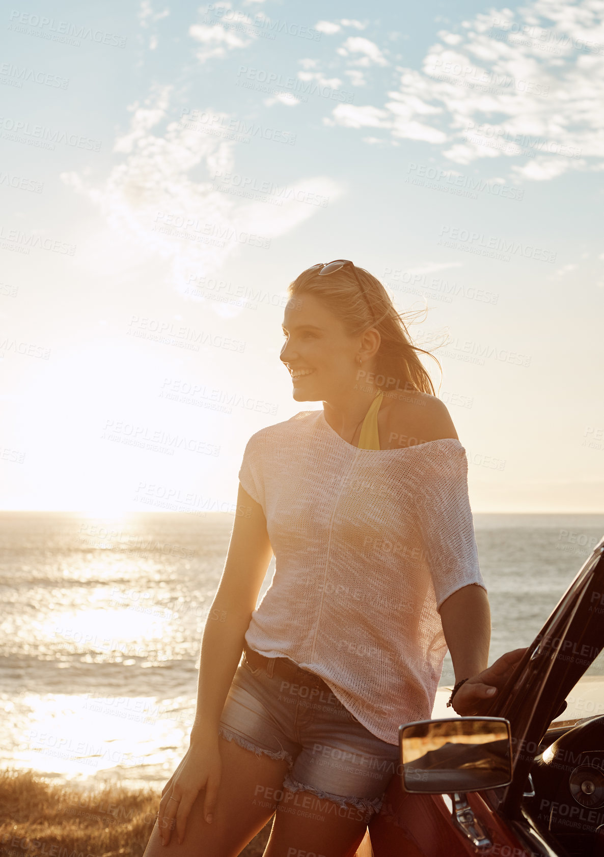 Buy stock photo Shot of a happy young woman enjoying a summer’s road trip