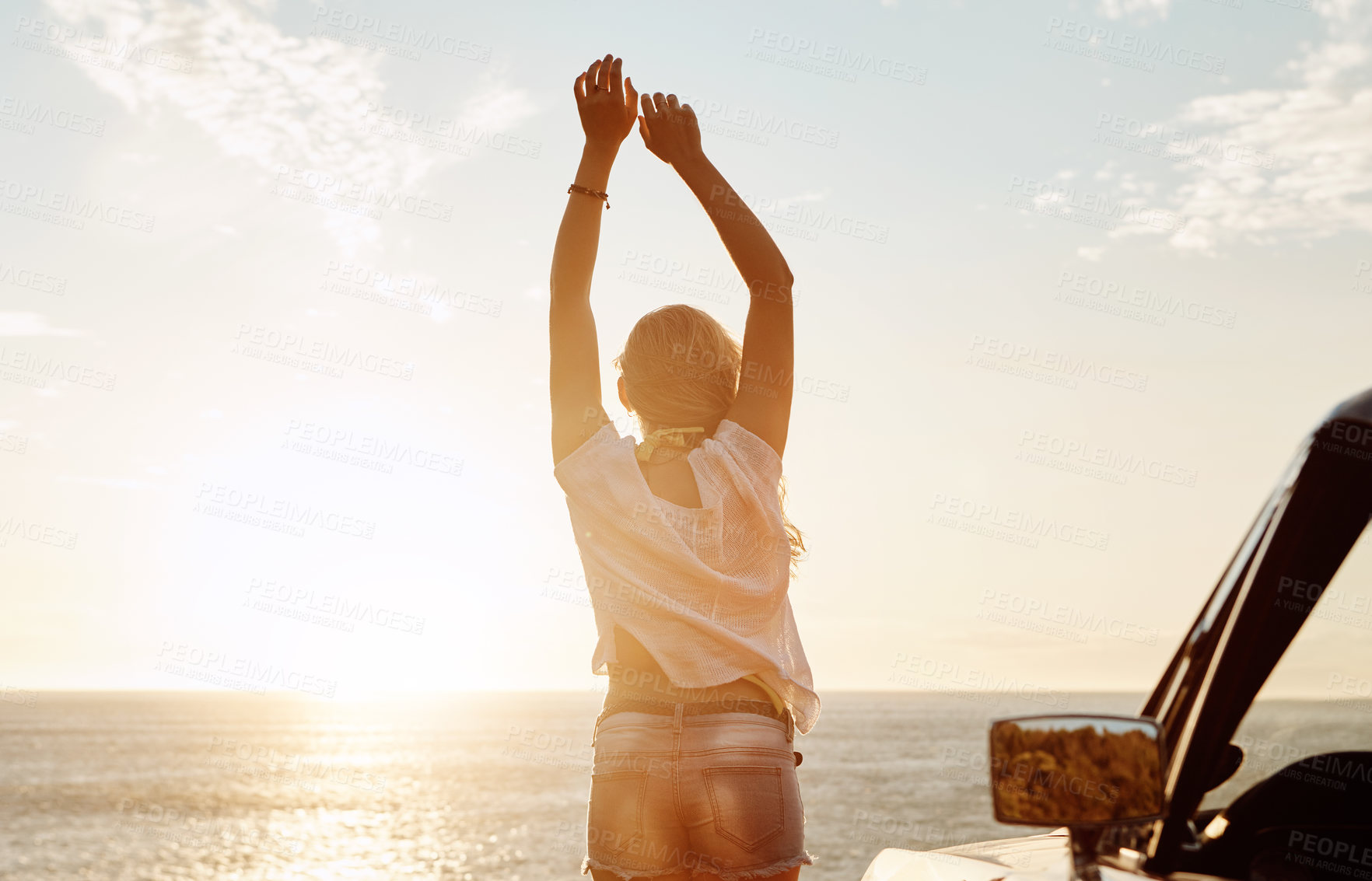 Buy stock photo Shot of a happy young woman enjoying a summer’s road trip