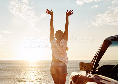 Buy stock photo Shot of a happy young woman enjoying a summer’s road trip