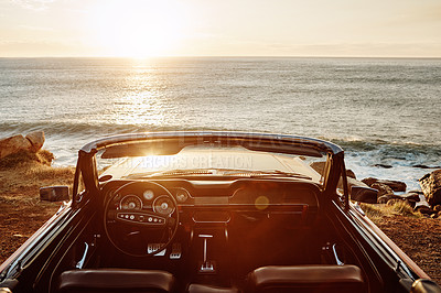 Buy stock photo Shot of an empty vintage car parked along the coast at sunset