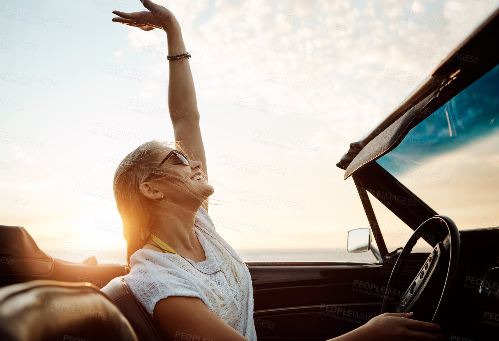 Buy stock photo Happy woman, celebration and driving convertible car for road trip, adventure and freedom on holiday or vacation. Excited young driver in luxury vehicle with dance, carefree and travel in sunset