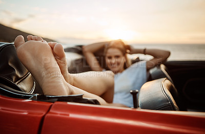 Buy stock photo Shot of a happy young woman enjoying a summer’s road trip