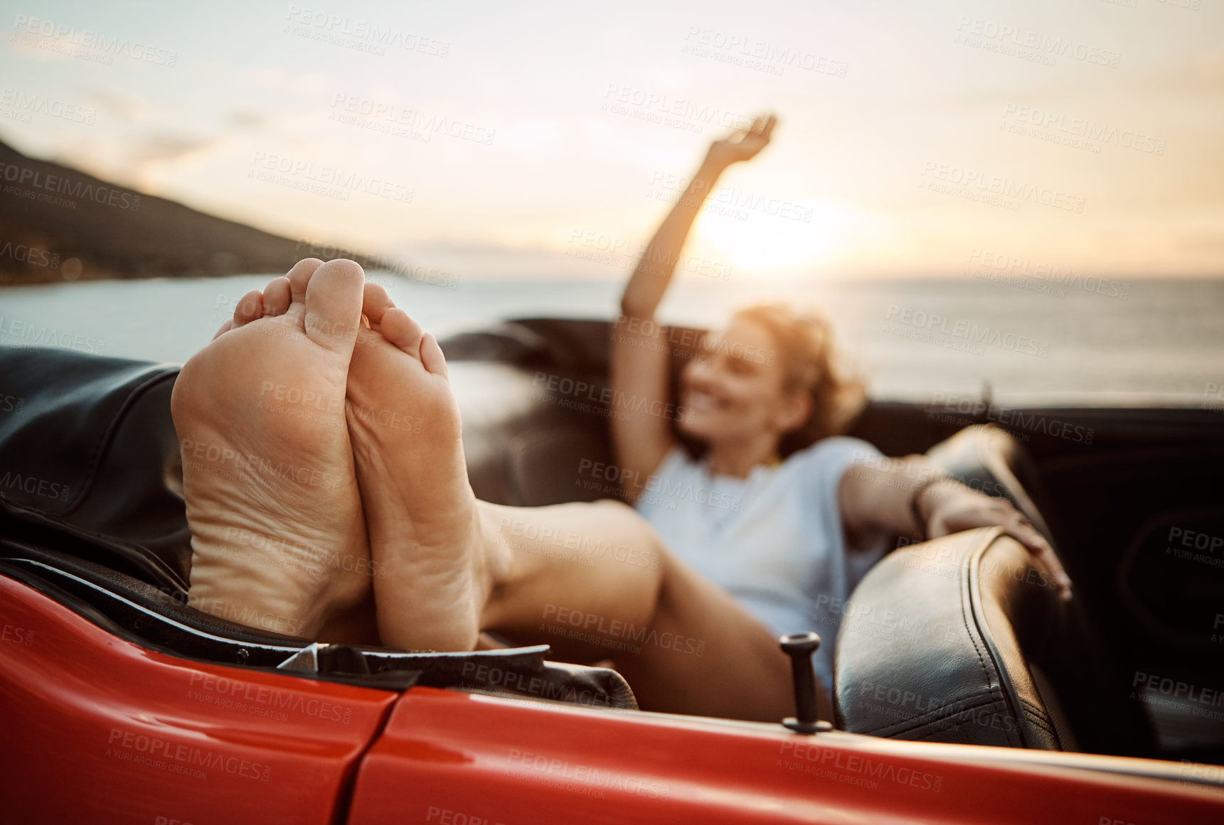 Buy stock photo Shot of a happy young woman enjoying a summer’s road trip