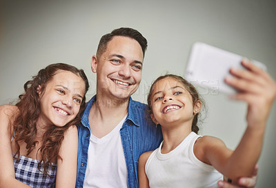 Buy stock photo Happy, father and children with selfie at house for photography, bonding together and social media post. Smile, man and kids with embrace of profile picture update, family safety and childhood memory