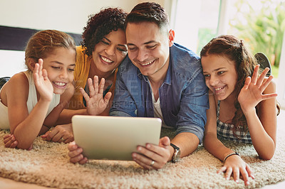 Buy stock photo Shot of a family of four video calling using a digital tablet