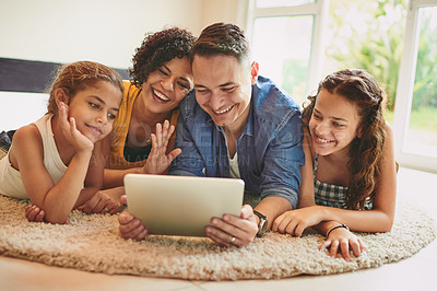 Buy stock photo Shot of a family of four video calling using a digital tablet