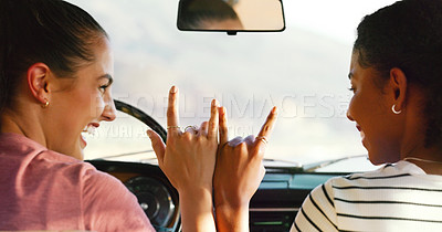 Buy stock photo Cropped shot of two attractive young women putting their hands together to make a sign in a vehicle