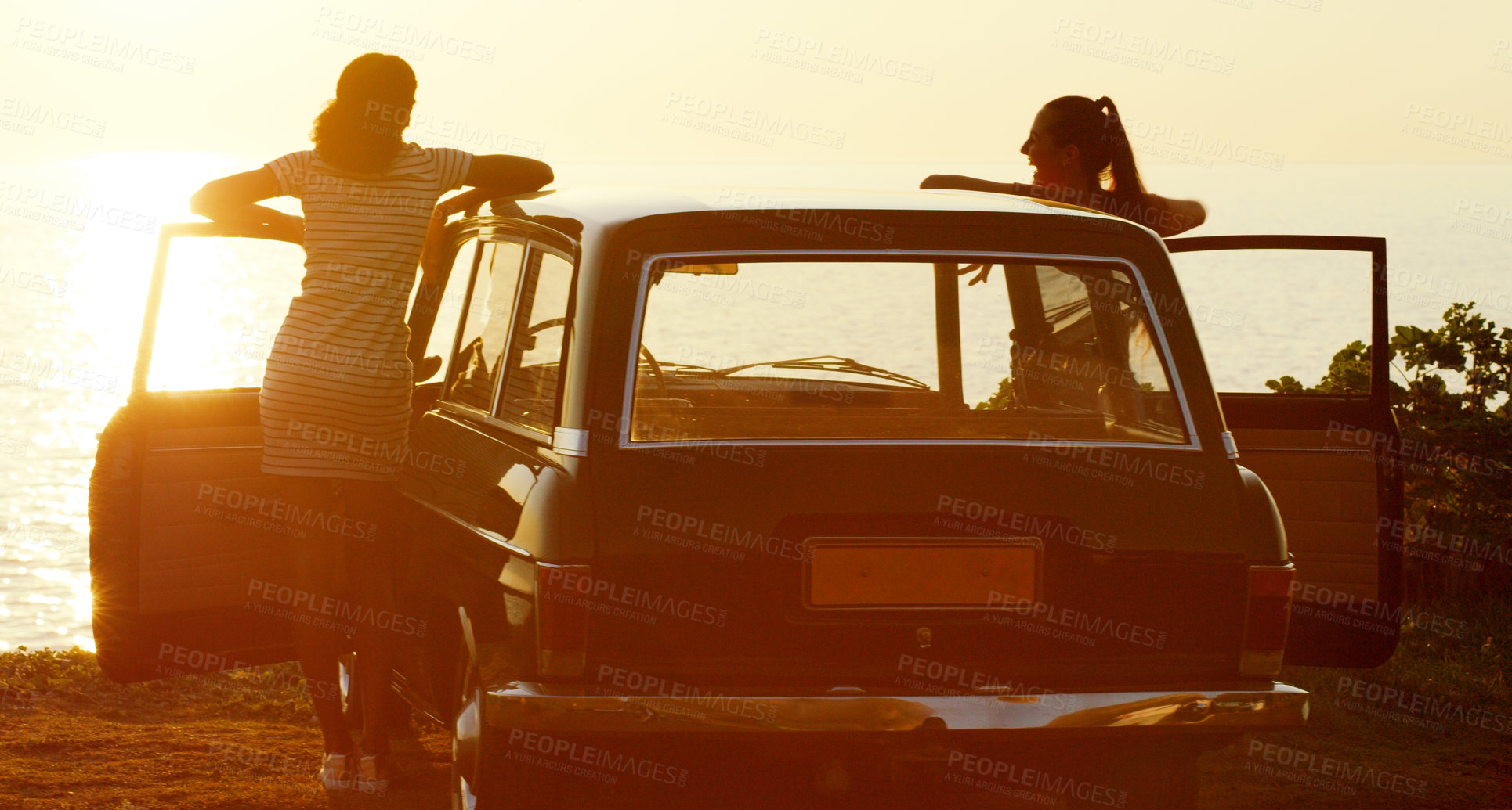 Buy stock photo Rearview shot of two young girl friends enjoying a stop at the beach during their roadtrip