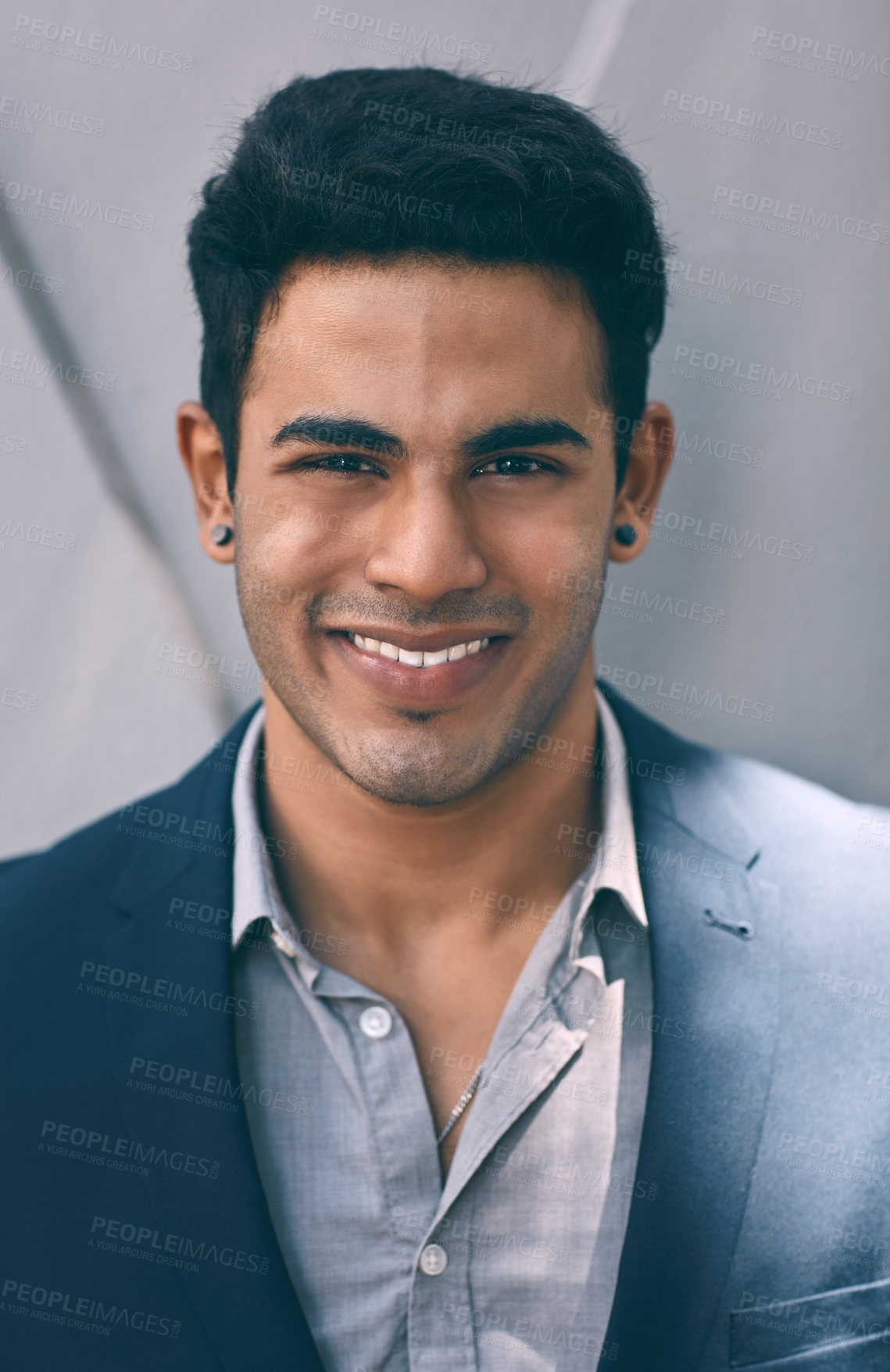 Buy stock photo Closeup portrait of a handsome young businessman standing against a grey wall