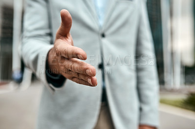 Buy stock photo Closeup shot of an unrecognizable businessman extending a handshake in the city