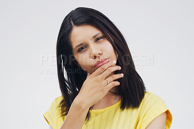 Buy stock photo Studio shot of a young woman looking thoughtful against a gray background