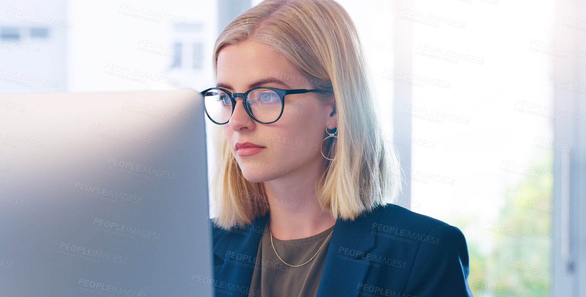 Buy stock photo Cropped shot of a focused young businesswoman working on her computer inside of the office
