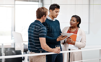 Buy stock photo Shot of a diverse group of colleagues at work discussing ideas on a tablet in the office