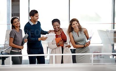 Buy stock photo Shot of a happy young group of colleagues sharing a laugh together in the office