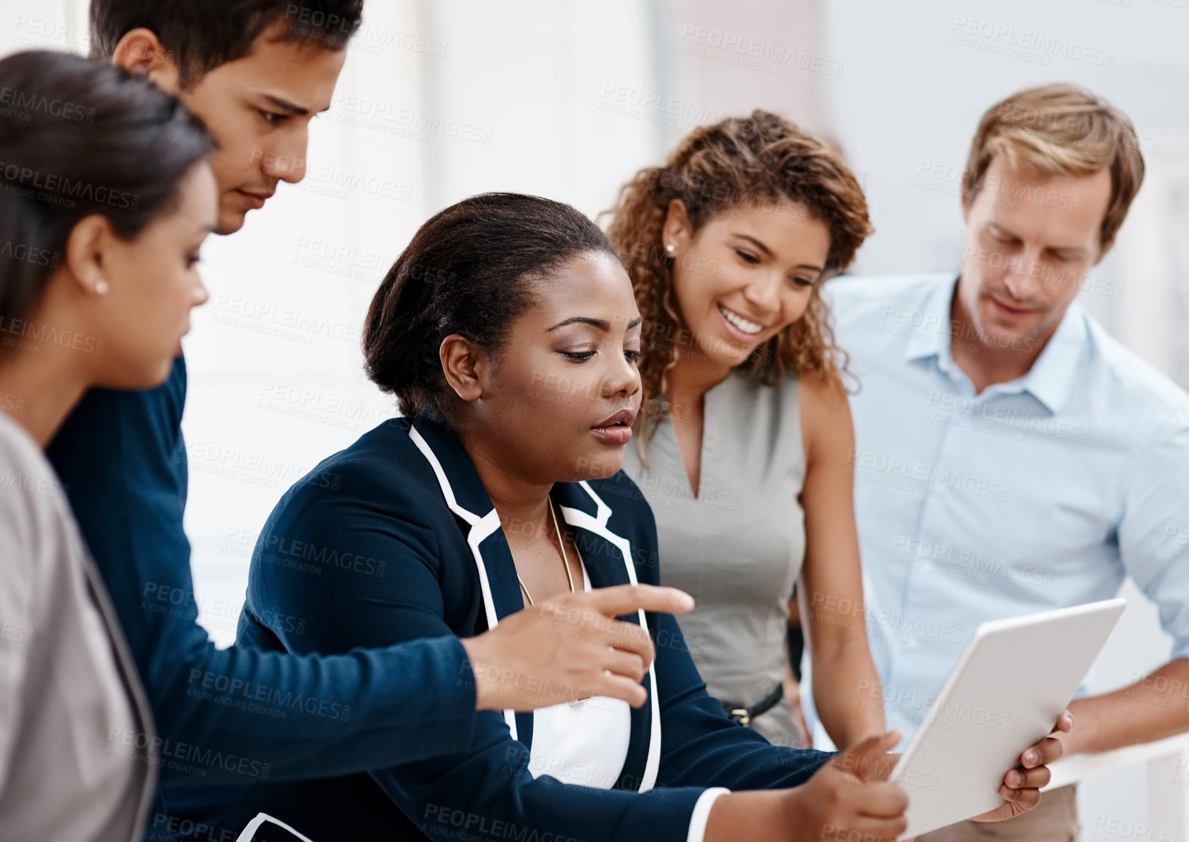 Buy stock photo Cropped shot of a diverse group of colleagues at work discussing ideas on a tablet in the office