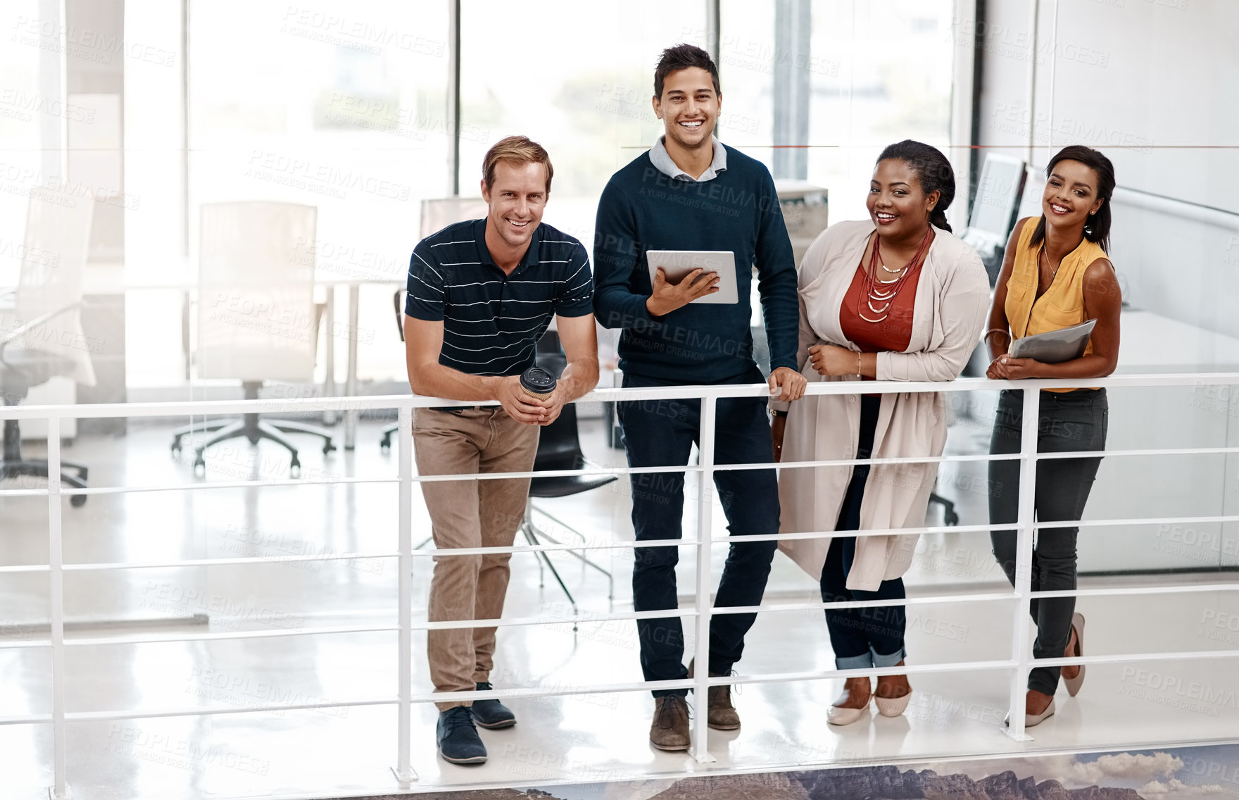 Buy stock photo Full length shot of a diverse group of colleagues standing together in the office and smiling at the camera