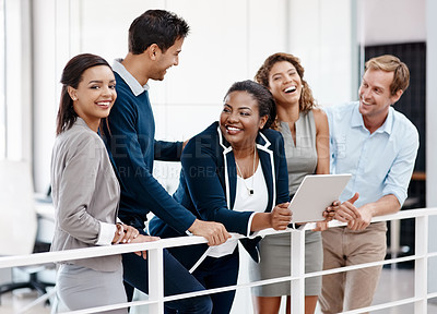 Buy stock photo Cropped shot of a happy diverse group of colleagues sharing a laugh together in the office