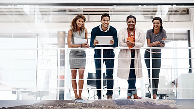 Buy stock photo Shot of a young diverse group of colleagues standing together in the office and smiling at the camera