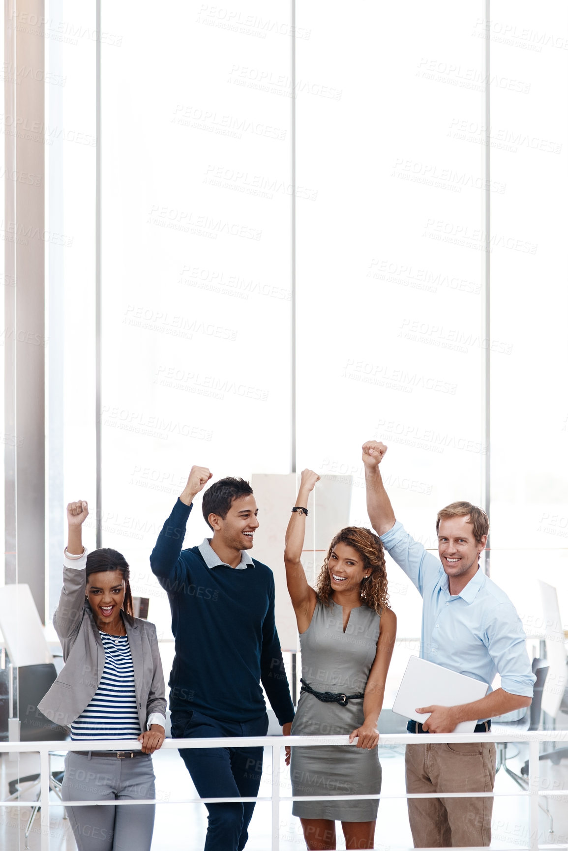 Buy stock photo Shot of a diverse group of colleagues celebrating success with their arm raised at the office