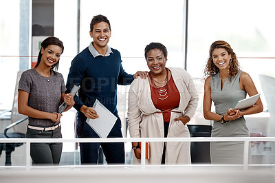 Buy stock photo Shot of a young diverse group of colleagues standing together in the office and smiling at the camera