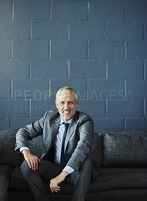 Buy stock photo Cropped portrait of a handsome and successful mature businessman sitting on a sofa in his office