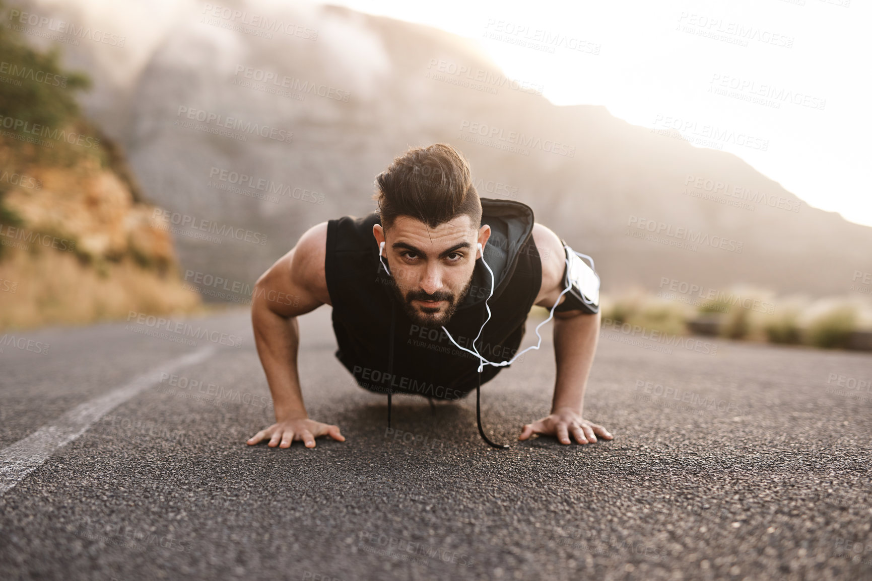Buy stock photo Portrait of a sporty young man doing pushups while exercising outdoors