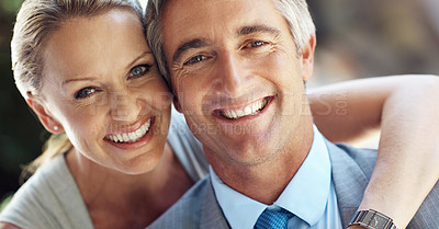Buy stock photo Cropped portrait of an affectionate mature business couple smiling and holding each other closely in front of the camera