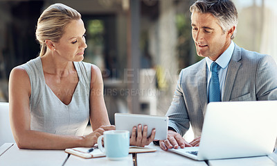 Buy stock photo Shot of a mature business couple viewing work together in the office on a tablet to plan their next move