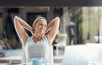 Buy stock photo Shot of a mature business woman taking a break at work and leaning back with her hands behind her head