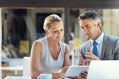 Buy stock photo Shot of a dedicated mature business couple discussing their ideas with each other in the office to improve their work