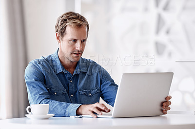 Buy stock photo Cropped shot of a handsome mature businessman using his tablet while sitting in the office